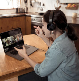 Молодая женщина за ноутбуком во время виртуальной встречи